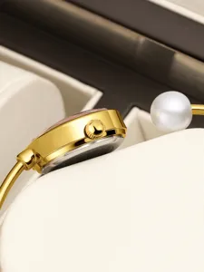 Women's gold bracelet watch with pearl detail elegant fashion timepiece for daily wear.