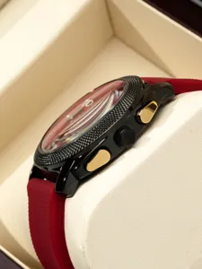 Detailed close-up of a men's quartz sport watch with a textured bezel and red rubber strap.