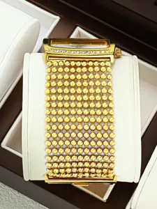 Detailed close-up of gold women watch with beaded mesh strap and sparkling crystal case.