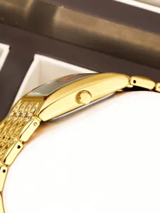 Reloj de mujer rectangular dorado de lujo con correa de cristal de estrás brillante vista lateral