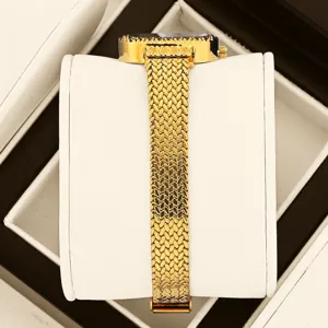 Detaillierte Nahaufnahme einer luxuriösen goldenen Damenuhr mit gewebtem Armband im Etui.
