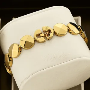 Close-up of luxury gold metal watch strap bracelet with circular links and delicate folding clasp.
