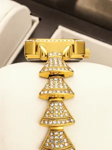 Luxury gold women watch with sparkling rhinestones, square dial, and unique layered pyramid bracelet design.