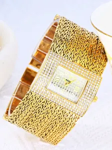 Nahaufnahme einer vergoldeten Damenarmbanduhr mit Strass-Zifferblatt und Metallarmband.