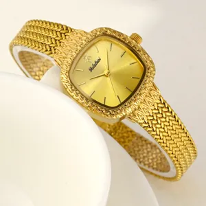 Detailaufnahme einer goldenen quadratischen Damenarmbanduhr mit strukturiertem Metallarmband.