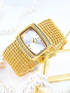 Gold rhinestone watch detail, elegant multi-strand bead strap, luxury dial close-up view.
