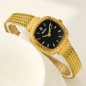 Detaillierte Nahaufnahme der goldenen Damenarmbanduhr mit schwarzem Zifferblatt.