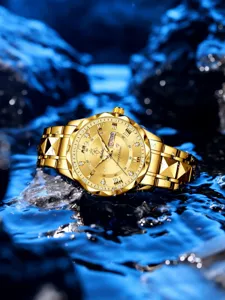 Detailaufnahme der goldenen Herren Quarzarmbanduhr mit Datumsanzeige auf Wasserspritzer.