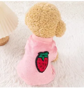 Close-up detail of cute pink pet four-leg warm fleece dog clothes with sweet strawberry embroidery.