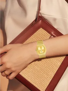 Golden tonneau quartz watch for women featuring dazzling full diamond paved dial and metal bracelet.