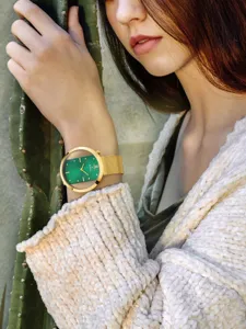 Elegant gold tone women quartz watch with green textured dial and mesh strap detail.