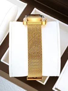 Gold square quartz watch for women with rhinestone bezel and mesh metal strap detail view.