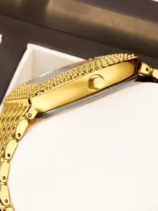 Gold tone tonneau quartz watch side detail, luxury studded bezel and fine mesh strap view.