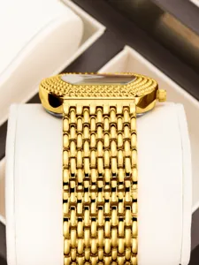 Exquisite gold women's watch detail featuring a sparkling crystal tonneau dial and mesh strap.