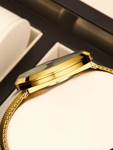 Detailed side view of luxury gold quartz watch with elegant mesh strap and polished case.