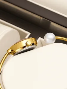 Elegante orologio bracciale da donna in oro con perla chic e design di lusso.