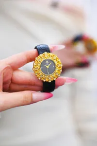Yalalusi luxury women wristwatch with ornate gold floral dial and black leather strap.