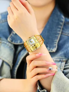 Vista detallada del reloj de pulsera dorado con pedrería brillante en la muñeca.