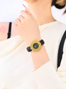 Detailed close-up of the luxury floral gold-cased women's watch with black leather strap.
