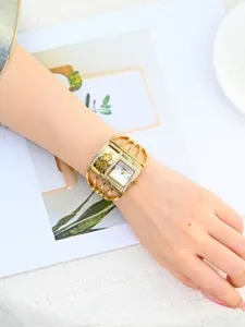 Elegante reloj de pulsera dorado para mujer con correa de jaula con pedrería, cuadrado.