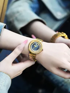 Gros plan sur la montre quartz pour femme en or avec lunette diamant et cadran abeille.