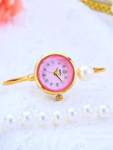 Primo piano di un orologio rigido da donna di lusso con quadrante rosa e perla elegante.