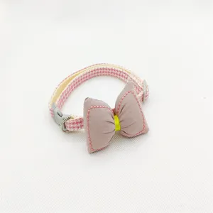 Close-up detail of the pink houndstooth pet collar featuring a cute bow and secure buckle.
