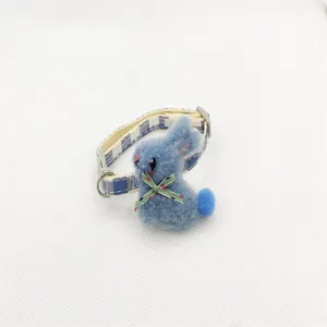 Gedetailleerd overzicht van de blauwe ruitjes huisdierhalsband met een schattig pluche konijn.