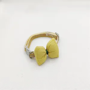 Pet collar with yellow bow and houndstooth pattern, cute accessory for cats and small dogs.