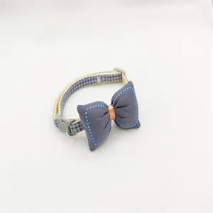 Detail shot of cute pet collar with grey bow tie, adjustable strap and metal ring.