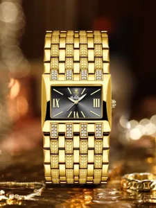 Lujoso reloj de mujer rectangular dorado con esfera negra, números romanos y pedrería brillante.
