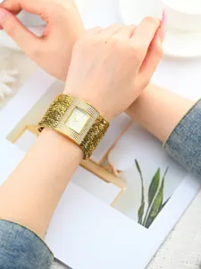 Elegante goldene Damen-Uhr mit funkelnden Strasssteinen und feinem Gliederarmband.