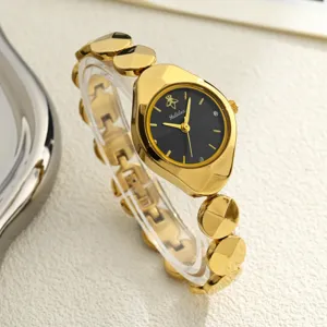 Detailed view of women gold wristwatch with black dial, elegant link bracelet and chic case design.