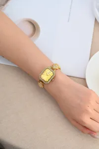 Luxury gold square rhinestone women's watch detail shot, elegant crystal dial metal bracelet.