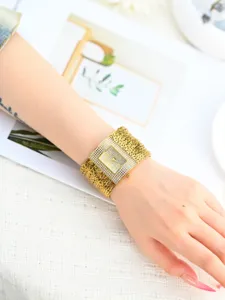 Goldene Strass Quadrant geflochtene Uhr Handgelenk Detail, elegante Damen Armbanduhr Nahaufnahme.