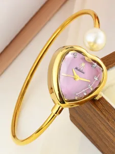 Exquisite heart-shaped dial watch detail with gold bangle and elegant pearl cuff design.