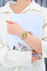 Close-up of luxury gold square dial women watch with sparkling rhinestones and strap.