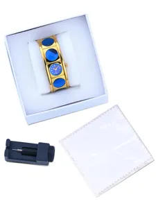 Gold vintage bangle watch for women with blue circular insets and quartz movement.