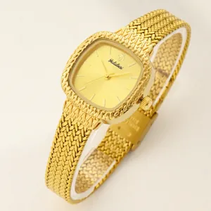 Detailansicht der eleganten quadratischen Damenuhr in Gold mit strukturiertem Metallarmband.
