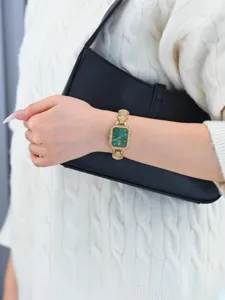 Green dial gold wristwatch detailed view featuring rhinestone accents and elegant design.