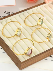 Elegant gold bangle watch for women, featuring a chic heart dial and pearl charm detail.