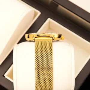 Reloj de cuarzo dorado para mujer con triángulo y correa de malla metálica elegante.