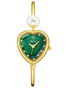 Detailed view of gold heart watch dial, green rhinestone face with elegant pearl accent.