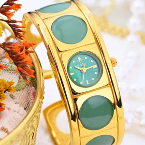 Vintage gold cuff quartz watch with green dial and stylish wide bracelet for elegant women.