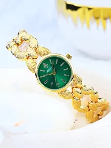 Primo piano dell'orologio da polso dorato con quadrante verde e fine trama del cinturino.