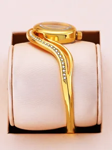 Elegant gold bangle watch for women with sparkling stone accents. Luxury style detail.