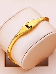 Luxury gold-tone women's bangle watch featuring a sleek minimalist design and elegant clasp.