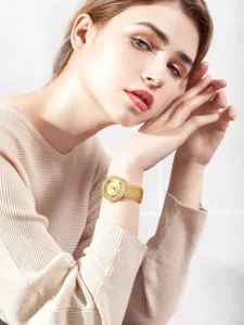 Close-up of women gold rhinestone quartz watch detail, elegant mesh strap, luxury fashion style.