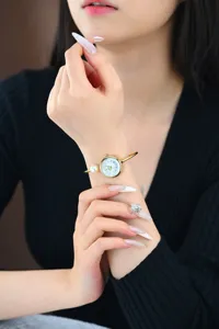 Primo piano dettaglio dell'orologio rigido da donna di lusso con perla e quadrante.