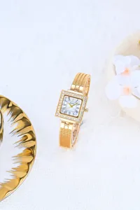 Elegant gold square quartz watch for women with rhinestone bezel and metal mesh strap.